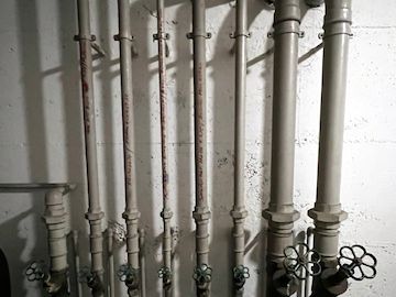 Verteiler nicht totraumfrei, ungedämmt im überhitzten Heizungsraum – typischer Mangel in einer Trinkwasserinstallation
